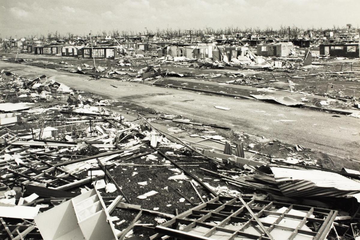 Street level view of house debris and a flattened city